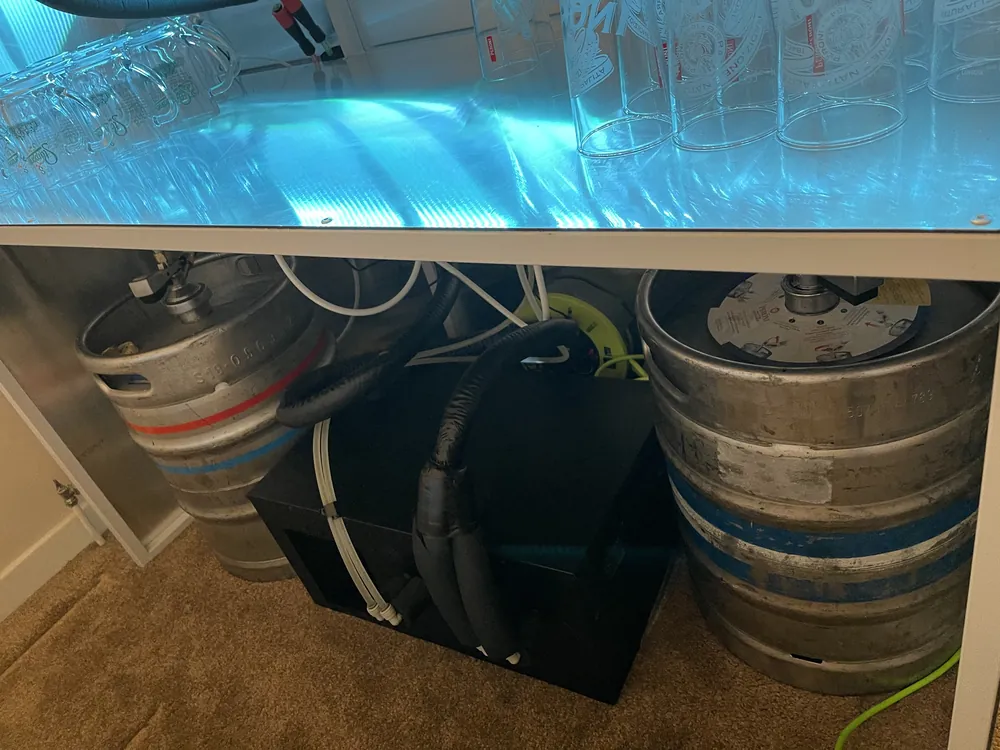 Two kegs and a python cooler under a home bar counter, part of a month-long Christmas home bar hire