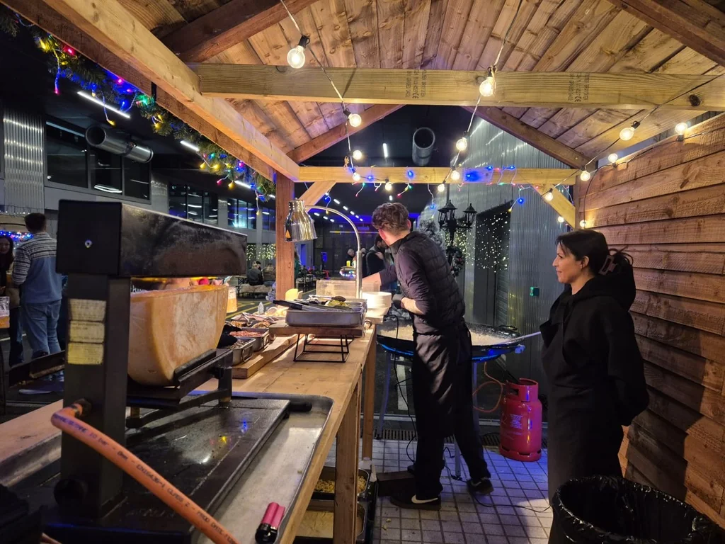 Inside an alpine-style wooden market hut at St Pancras Campus at night