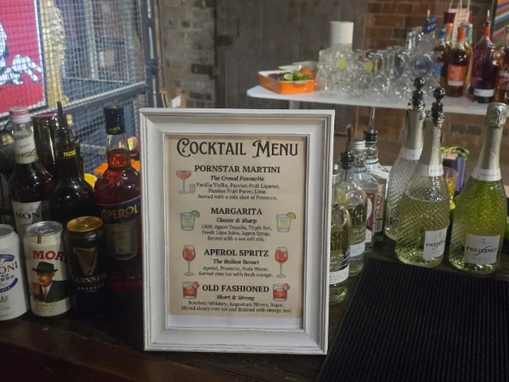 Printed four-drink cocktail menu on a staffed bar in Birmingham