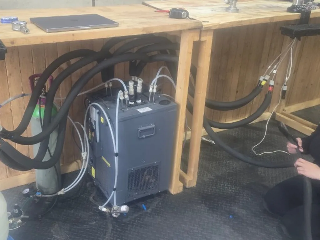 Eight-tap wedding bar being built in the unit, with flash cooler and lines under rustic wooden counters
