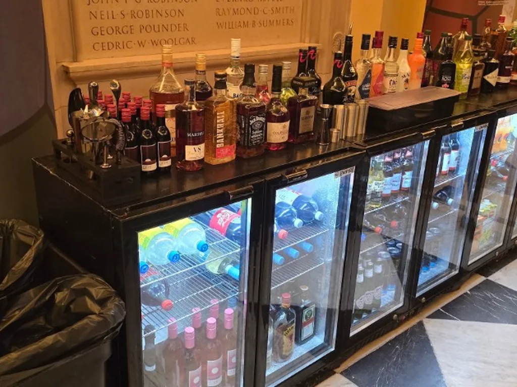 Row of glass-front bottle fridges used as a back bar