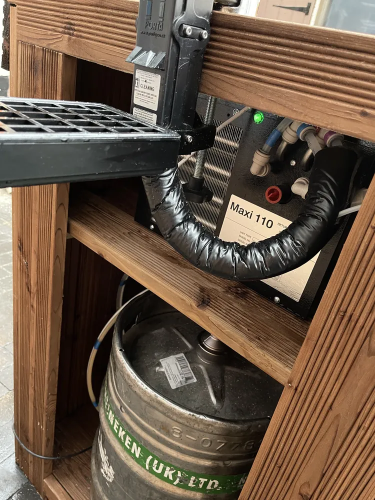 Inside a small wooden keg hire bar: a Maxi 110 python cooler on the shelf above a keg
