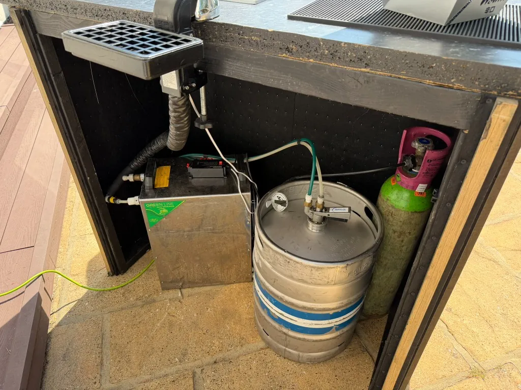 Typical keg hire setup with keg, flash cooler and gas bottle under a portable bar