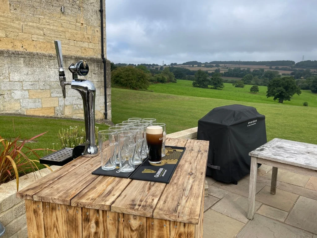 Guinness harp tap and poured pint on a rustic wooden bar near Cheltenham