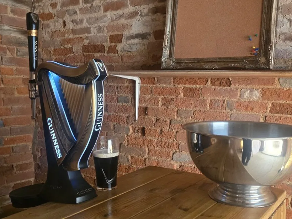 Guinness harp tap and poured pint on a wooden table in Great Bowden