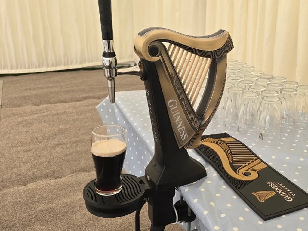 Guinness harp font clamped to a table in a marquee near Swindon