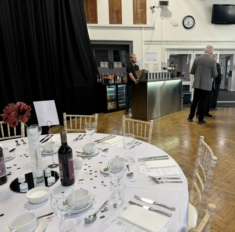 Luke behind a stainless mobile bar at Raynes Park High School annual dinner