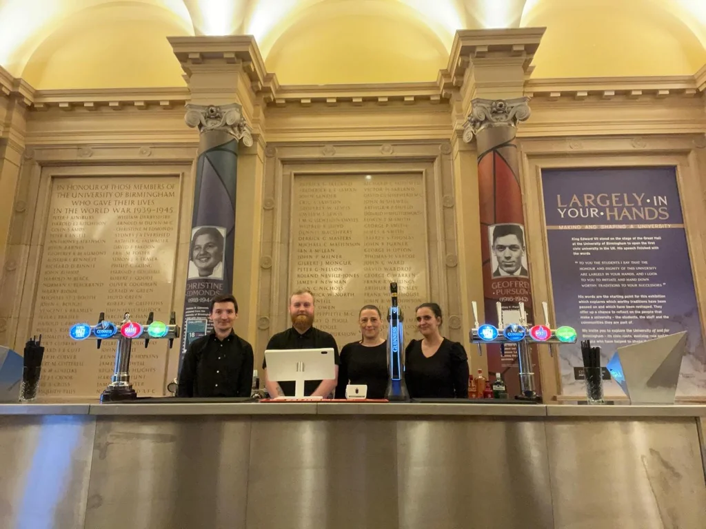 Bar Hire UK team behind a stainless steel bar at the University of Birmingham