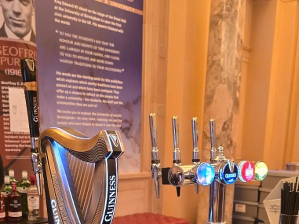 Guinness harp font and four-tap chrome font on a stainless bar at the University of Birmingham